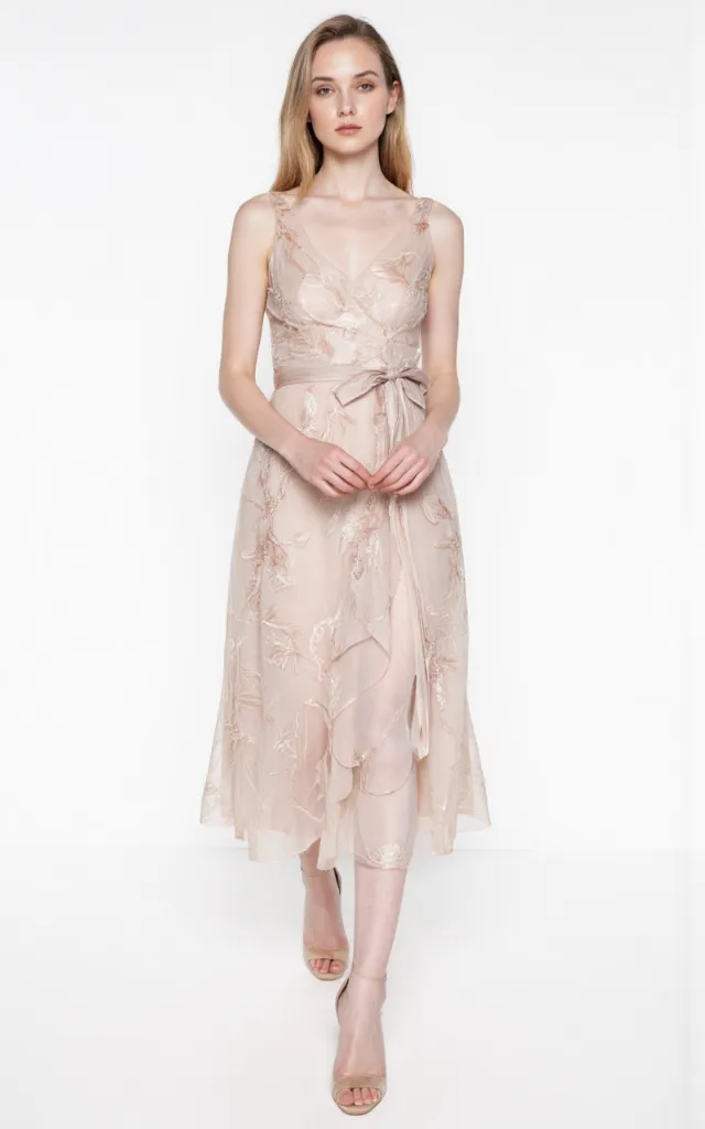 A French female model wearing Elegant   style clothing, against a white background, in a front   facing shot focusing on shoes